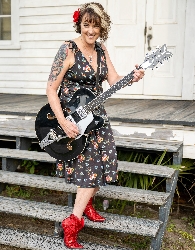 Kellie Parr is a musician in a dress with red boots